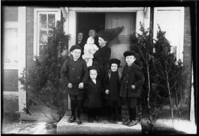 8 personer stående i dörröppning.
