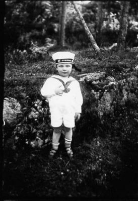 Pojke stående i naturen.
Nyckelord: Mössa