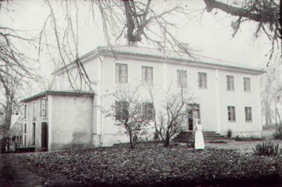 Kvinna stående framför byggnad.
Nyckelord: Uniform