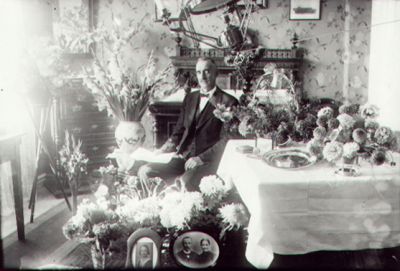 Man sittande bland blommor i rum.
Nyckelord: Blommor Fotografi