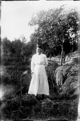 Kvinna stående i naturen.
Nyckelord: Vatten Berg Gärdesgård