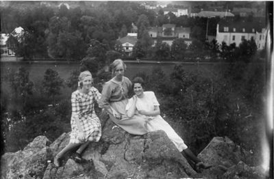 3 kvinnor sittande på berg med byggnader i bakgrunden.
Nyckelord: Berg Vattendrag Utsikt