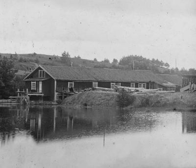 Byggnad timmer och virke invid vattendrag
Nyckelord: Timmer Virke