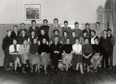 Man och ett antal sittande och stående barn i klassrum
Nyckelord: Klassrum, Skolsal, Realskola