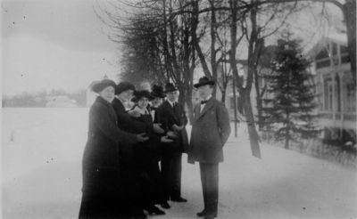 3 män och 3 kvinnor stående i snön intill vattendrag.
Nyckelord: Vinter