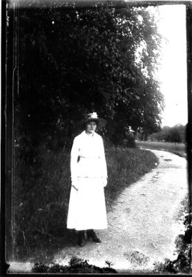 Kvinna stående på väg intill vattendrag.
Nyckelord: Väg