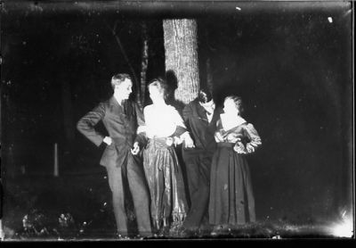 2 män och 2 kvinnor stående framför träd.
