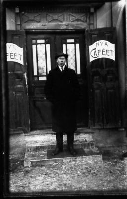 Man stående på trappa till café.
Nyckelord: Café Entré