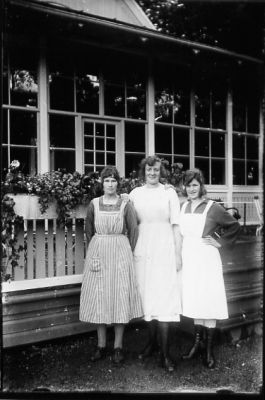 3 kvinnor stående framför veranda.
Nyckelord: Veranda