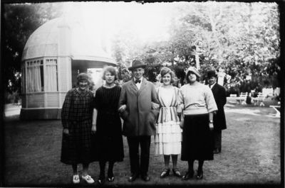 2 män och 4 kvinnor stående framför byggnad.
