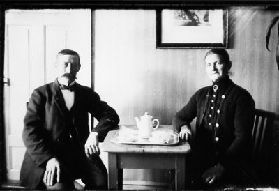 Man och kvinna sittande vid bord med kaffebricka.
Nyckelord: Kaffe Tavla