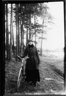 Kvinna stående med cykel i skogsbacke.
Nyckelord: Cykel Skog