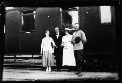 2 män och 2 kvinnor stående framför järnvägsvagn.
Nyckelord: Järnvägsvagn