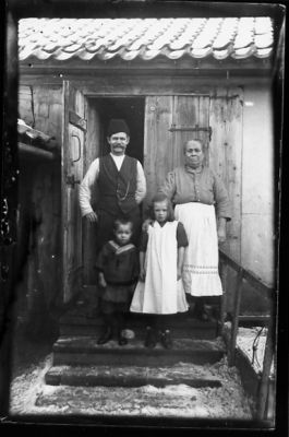 Man, kvinna, pojke och flicka stående på trappa till byggnad.
Nyckelord: Vinter