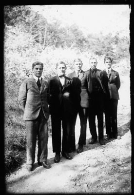 5 män stående på grusgång.
