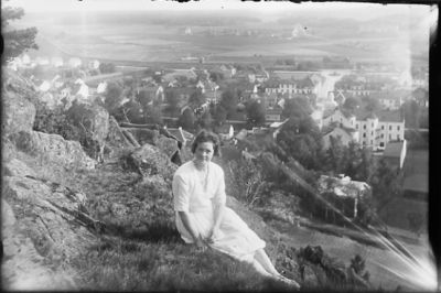 Kvinna sittande på berg med stadsvy i bakgruden.
Nyckelord: Utsikt