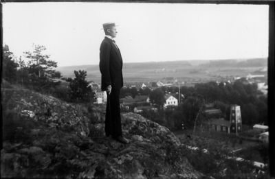 Man stående på berg med stadsvy i bakgrunden.
Nyckelord: Utsikt