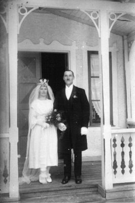 Brudpar stående på veranda.
Nyckelord: Veranda Bostad Brudbukett Brudkrona