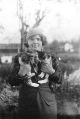 Kvinna stående med 2 katter.
Nyckelord: Katt