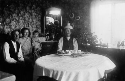 2 män och kvinna med barn sittande i rum.
Nyckelord: Kaffebord Spegel Tapet
