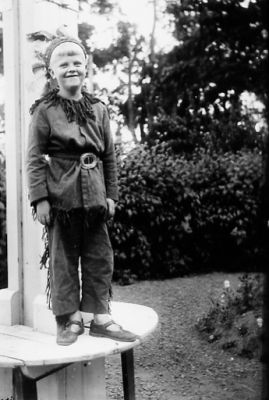 Indianklädd pojke stående på trädgårdsbord.
Nyckelord: Bord Park Dräkt