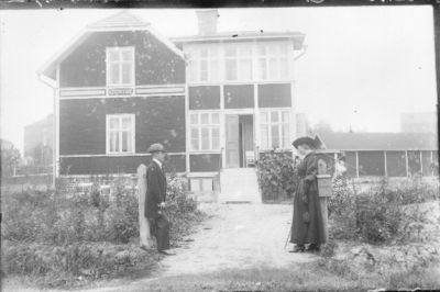 Man och kvinna stående vid grindhål.
Nyckelord: Grindstolpe