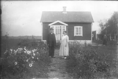 Man och kvinna stående framför byggnad.
Nyckelord: Blommor Gång