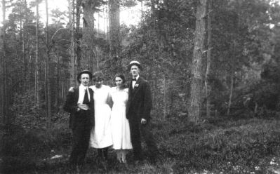 2 män och 2 kvinnor stående i skogsbacke.
Nyckelord: Skogsbacke Skog