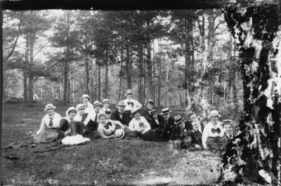 6 män och 9 kvinnor sittande i skogsbacke.
Nyckelord: Skogsbacke Skog Dragspel