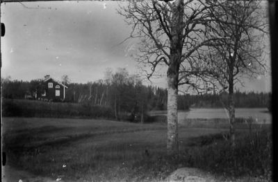 Byggnad på tomt intill  vatten.
Nyckelord: Träd Landskapsvy