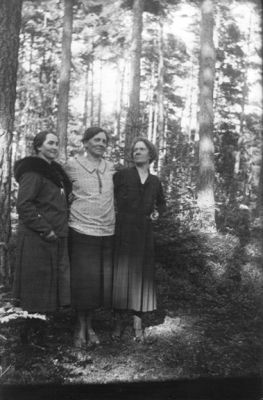 3 kvinnor stående i skogsbacke.
Nyckelord: Skogsbacke Skog