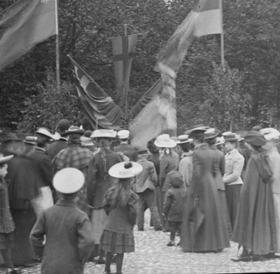 Ett antal kvinnor och barn vid flaggor och banderoller
Nyckelord: Flagga Banderoll