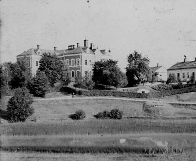 Stor byggnad med kringbebyggelse på höjd
