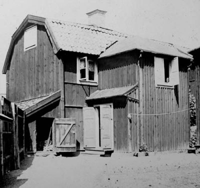 Träbyggnad med gårdsplan framför
