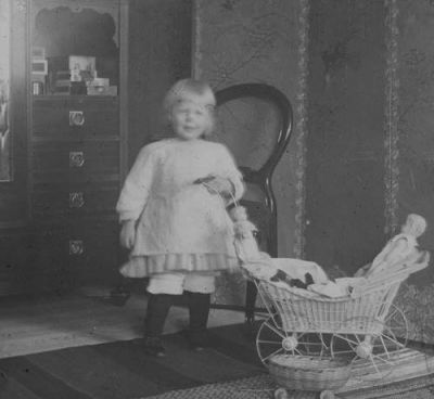 Flicka i rum med docka i dockvagn
Nyckelord: Dockvagn Docka