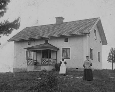 2 kvinnor framför byggnad
