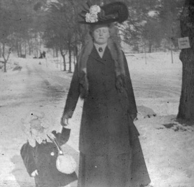 Kvinna och flicka på promenad i vinterlandskap
