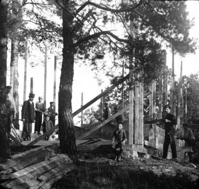 4 män och 3 pojkar vid nybygge i skogen
Nyckelord: Virke