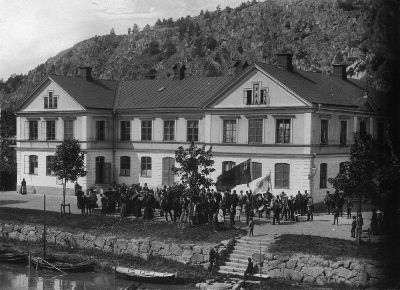 En stor grupp människor framför en större byggnad
