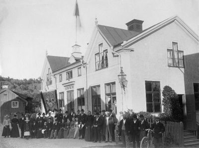 En samling människor framför en byggnad
