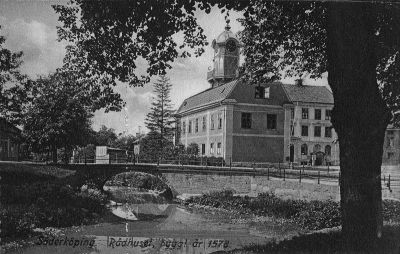 Byggnad vid torg och bro över vattendrag

