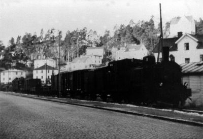 Ångloksdraget tåg med bebyggelse i bakgrunden
Nyckelord: Ånglok Järnväg
