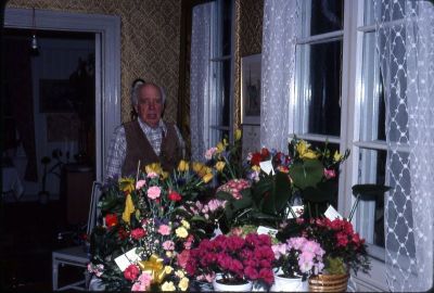 Man vid blomsterfyllt bord
