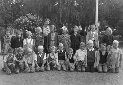 Skolklass med lärarinna på skolgård
