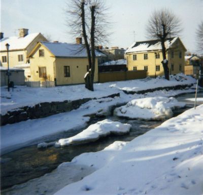 Stadsvy utmed vattendrag vintertid
