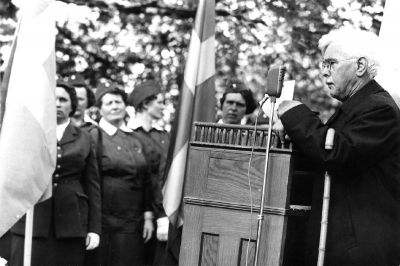 Man i talarstol, lottor i bakgrunden
Nyckelord: Uniform Talarstol