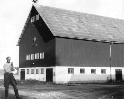 Man stående vid ladugård
