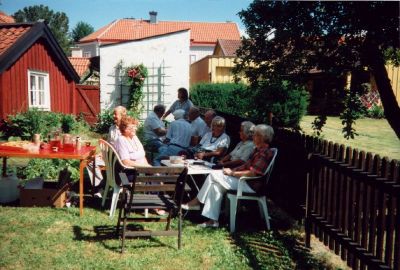 Män och kvinnor sittande i trädgård
Nyckelord: Trädgård