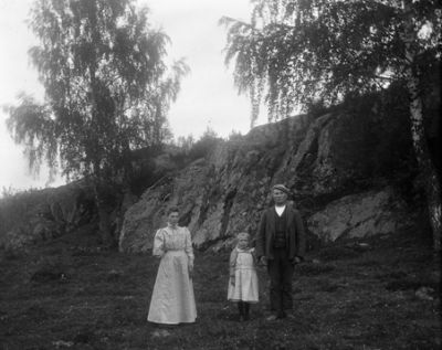 Man, kvinna och flicka stående nedanför berg
Nyckelord: Klänning Kostym