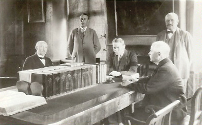 5 män runt sammanträdesbord med inbundna böcker
Nyckelord: Ordförandeklubba